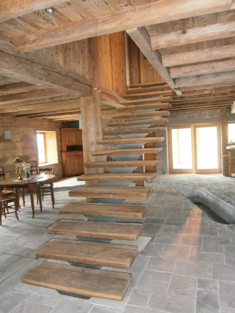 Escalier limon central en vieux bois et acier. Plafond mur et poutrage